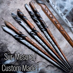 Könnte beinhalten: Ein Set aus sechs Holzstäben mit aufwendigen Schnitzereien und silbernen Akzenten. Die Stäbe sind mit Runen verziert und haben eine dunkelbraune Oberfläche. Sur-Mesure! Maßgefertigt!