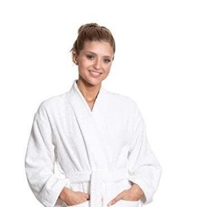 Puede incluir: Una bata de ba&ntilde;o blanca con cuello chal y cintur&oacute;n de atar. La bata tiene dos bolsillos en la parte delantera.