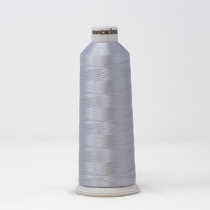 May include: A spool of silver gray Madeira thread.