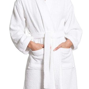 Puede incluir: Albornoz blanco con cuello chal, mangas largas y cintur&oacute;n de atar. La bata tiene dos bolsillos de parche en la parte delantera.