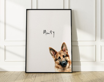 Puede incluir: Una impresión enmarcada en negro con una ilustración de acuarela de un perro pastor alemán mirando a la cámara. El nombre del perro, "Monty", está escrito en cursiva negra en la parte superior de la impresión.