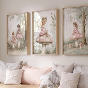 May include: Three framed watercolor prints of fairies in a forest setting. The fairies wear pink dresses and sit on mushrooms. The prints are displayed above a wooden bench with pillows and baskets. The color palette is soft, with muted greens, pinks, and beige.
