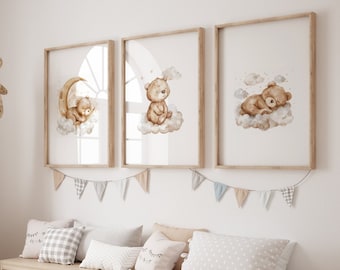 May include: Three framed watercolor prints of brown bears sleeping on clouds. The prints are hung on a white wall above a wooden bench with storage bins. A woven giraffe toy stands next to the bench.