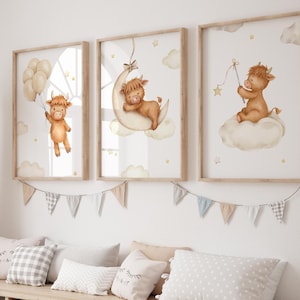 K&ouml;nnte beinhalten: Drei gerahmte Kunstdrucke f&uuml;r das Kinderzimmer mit Aquarellillustrationen eines Highland-K&auml;lbchens. Ein Kalb h&auml;lt Ballons, ein anderes ruht auf einem Mond, und das dritte sitzt auf einer Wolke und h&auml;lt einen Stern. Die Drucke sind in einem Kinderzimmer.