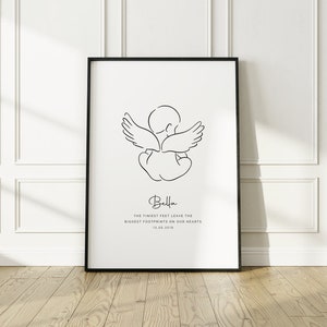 Puede incluir: Impresión en blanco y negro de arte de línea de un ángel bebé con alas. La impresión tiene el texto "Bella, Los pies más pequeños dejan las huellas más grandes en nuestros corazones, 13.08.2019."