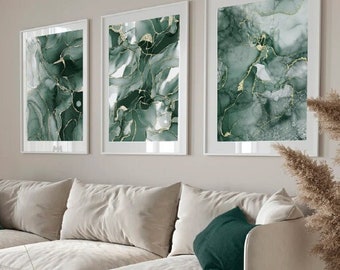 May include: A white sectional sofa with green throw pillows in a living room with three abstract art prints featuring green and gold marble patterns. The prints are framed in white and hung on a light beige wall. A green velvet curtain is visible in the background.