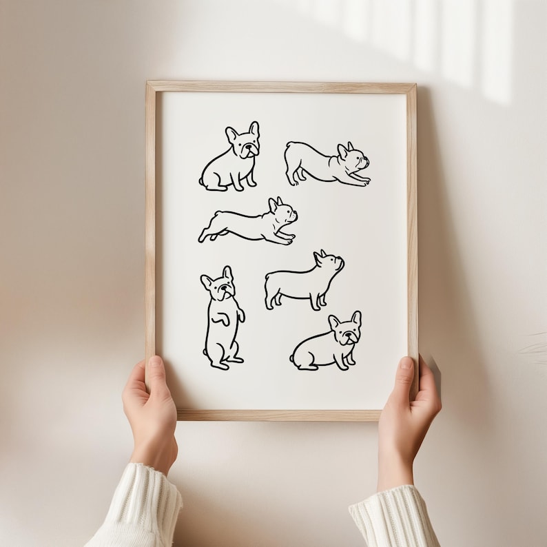 May include: A framed print featuring six black line drawings of French Bulldogs in various poses. The dogs are depicted sitting, running, and standing. The frame is a light wood color, and the background is a neutral white.