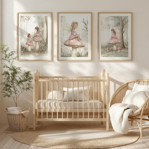 May include: Three framed watercolor prints of fairies in a forest setting. The fairies are wearing pink dresses and sitting on mushrooms. The prints are displayed above a light wood crib, a wicker chair, and a round jute rug.