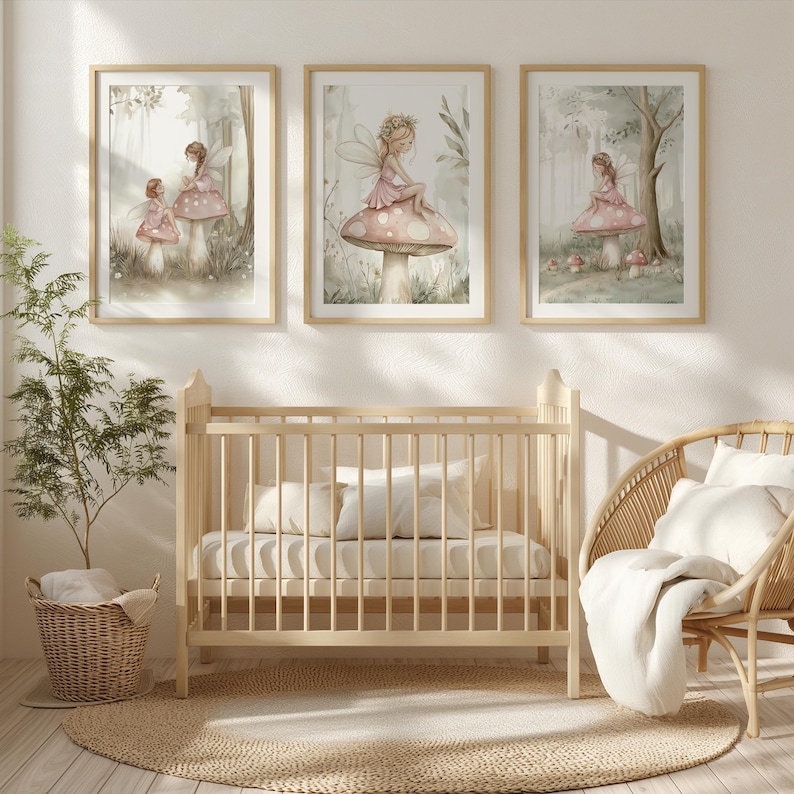 May include: Three framed watercolor prints of fairies in a forest setting. The fairies are wearing pink dresses and sitting on mushrooms. The prints are displayed above a light wood crib, a wicker chair, and a round jute rug.
