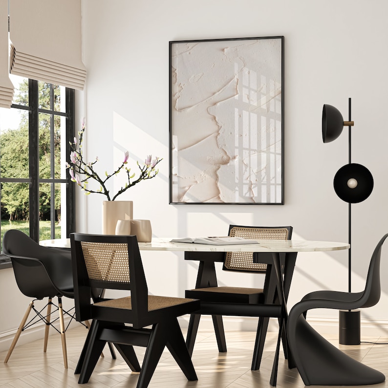 May include: A modern dining room with a white marble table, black chairs, and a black floor lamp with a round shade. A vase with a branch of pink flowers sits on the table.