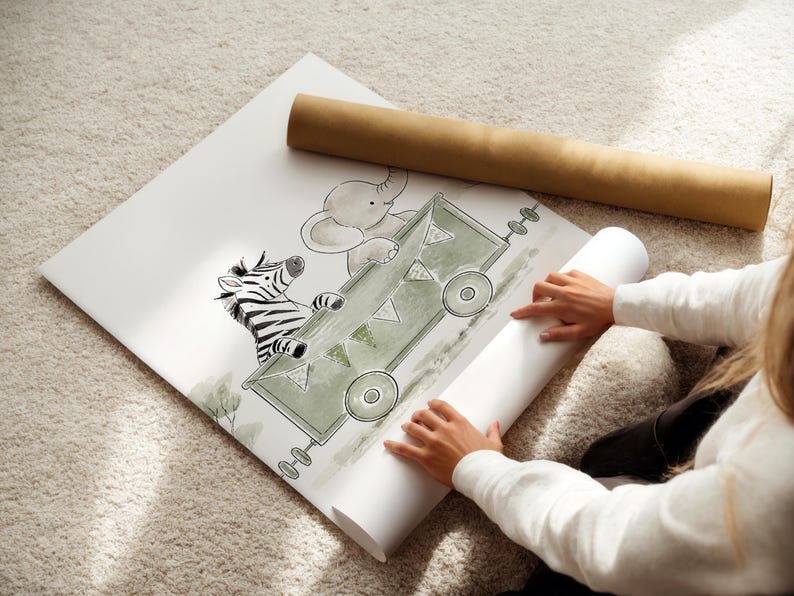 May include: A white poster featuring a green illustrated train carriage carrying a zebra and an elephant. The train car is decorated with small triangular bunting flags and has circular wheels. The artwork is rendered in a soft, sketch-like style.