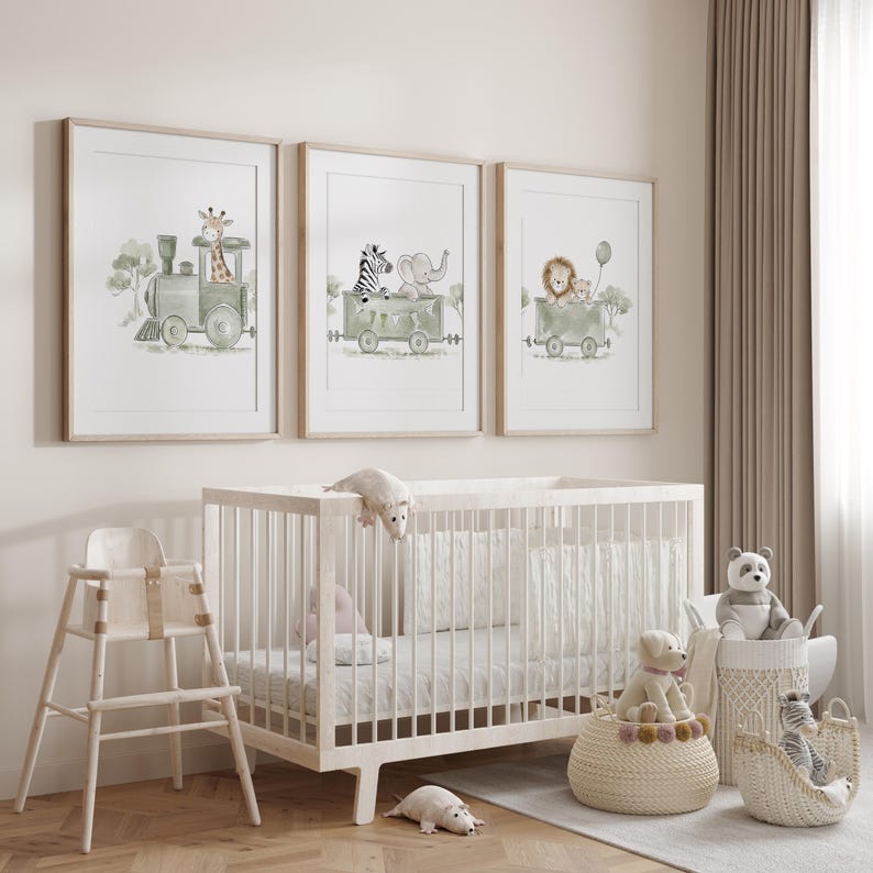 May include: Three framed watercolor prints featuring animals in train cars, including a giraffe, zebra, elephant, lion, and monkey. The prints are displayed above a light-colored wooden crib, a high chair, and woven baskets containing plush toys.