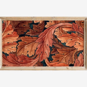May include: Framed artwork featuring a stylized pattern of orange and brown leaves on a dark blue background.