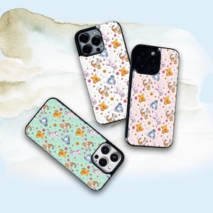 Puede incluir: Tres fundas para teléfono con un patrón de Winnie de Pooh y Piglet. Las fundas son negras con un fondo blanco, rosa y verde. El patrón presenta a Winnie de Pooh, Piglet y tarros de miel.