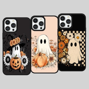 Pode incluir: Três capas de telemóvel com designs de Halloween. Uma capa apresenta um fantasma com um chapéu de bruxa, rodeado por flores e uma abóbora. Outra tem um fantasma com uma abóbora e flores. A terceira capa tem um fantasma com flores e um padrão xadrez.