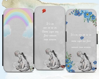 May include: Three phone cases featuring a grey donkey with a rainbow, a red leaf, and blue flowers. The cases have the text "It's ok not to be ok. Some days are just harder than others."