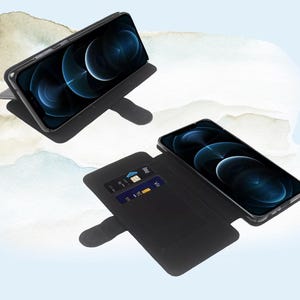 以下が含まれることがあります： カードホルダー内蔵の黒い革製の携帯電話ケース。ケースが開いており、携帯電話が見えます。携帯電話は、濃い青色の背景に白いアップルのロゴがついた黒い画面です。