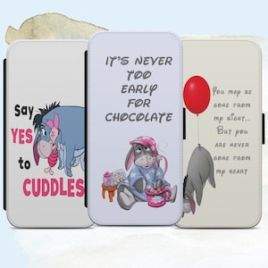 Puede incluir: Tres fundas para teléfono con personajes de Winnie the Pooh. La primera funda dice "Say YES to CUDDLES" y presenta a Winnie the Pooh y Piglet. La segunda funda dice "IT'S NEVER TOO EARLY FOR CHOCOLATE" y presenta a Winnie the Pooh en pijama sosteniendo una taza. La tercera funda presenta a Winnie the Pooh sosteniendo un globo rojo y dice "You may be gone from my sight... But you are never gone from my heart."