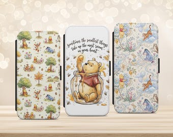 May include: Three rectangular phone cases featuring Winnie the Pooh characters. The left case has a repeating pattern of Pooh, Tigger, and Eeyore. The center case shows Pooh in a honey jar with the text Sometimes the smallest things take up the most room in your heart. The right case displays a floral pattern with Pooh, Tigger, Eeyore, and Piglet.