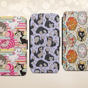 May include: Three rectangular phone cases featuring cartoon cat illustrations. The left case has a pink and yellow striped background with various cats. The middle case has a light purple background with black cats and stars. The right case has a cream background with cats in floral frames.