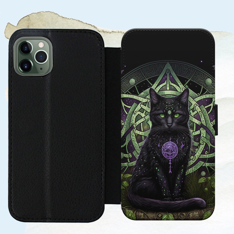 Puede incluir: Funda de tel&eacute;fono negra con un dise&ntilde;o de nudo celta verde y morado y un gato negro con ojos verdes en el centro. El gato sostiene un orbe morado con una estrella en su interior.