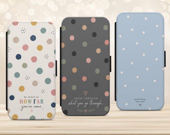 May include: Three rectangular phone cases featuring polka dot patterns. The left case is white with multicolored dots and the text BE PROUD OF HOW FAR you've come. The center case is dark gray with muted dots and the text GROW THROUGH what you go through. The right case is light blue with white dots and the text good things take time.