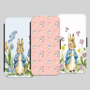 May include: Three phone cases featuring Peter Rabbit. The first case has a blue background with Peter Rabbit standing in a field of flowers. The second case has a pink background with a repeating pattern of Peter Rabbit in a field of flowers. The third case has a white background with Peter Rabbit standing in a field of flowers.