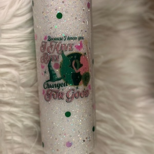 Puede incluir: Un vaso blanco con purpurina con una tapa rosa y un gráfico verde y rosa que dice "Because I knew you I have been changed for good".