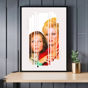 May include: A white poster with a black frame featuring a portrait of two women with blonde hair. The women are partially obscured by vertical white bars. The text "ABSOLUTELY FABULOUS" is written vertically on the poster.