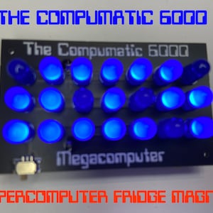 Könnte beinhalten: Ein blauer LED-Leuchtmagnet für den Kühlschrank in Form eines Computers mit dem Text "The Compumatic 6000 Megacomputer" und "SUPERCOMPUTER FRIDGE MAGNET".
