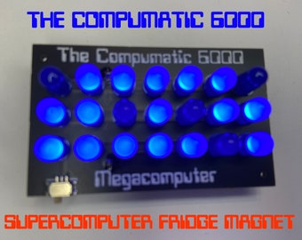 May include: A blue LED light-up fridge magnet shaped like a computer with the text "The Compumatic 6000 Megacomputer" and "SUPERCOMPUTER FRIDGE MAGNET".