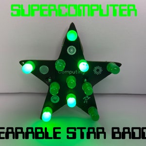 May include: A green star-shaped wearable badge with the text "Computing" and multiple green LEDs. The badge is labelled "SUPERCOMPUTER WEARABLE STAR BADGE".