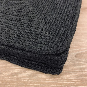 Könnte beinhalten: Eine schwarze gewebte Tragetasche mit einem dicken, doppelt genähten Rand.