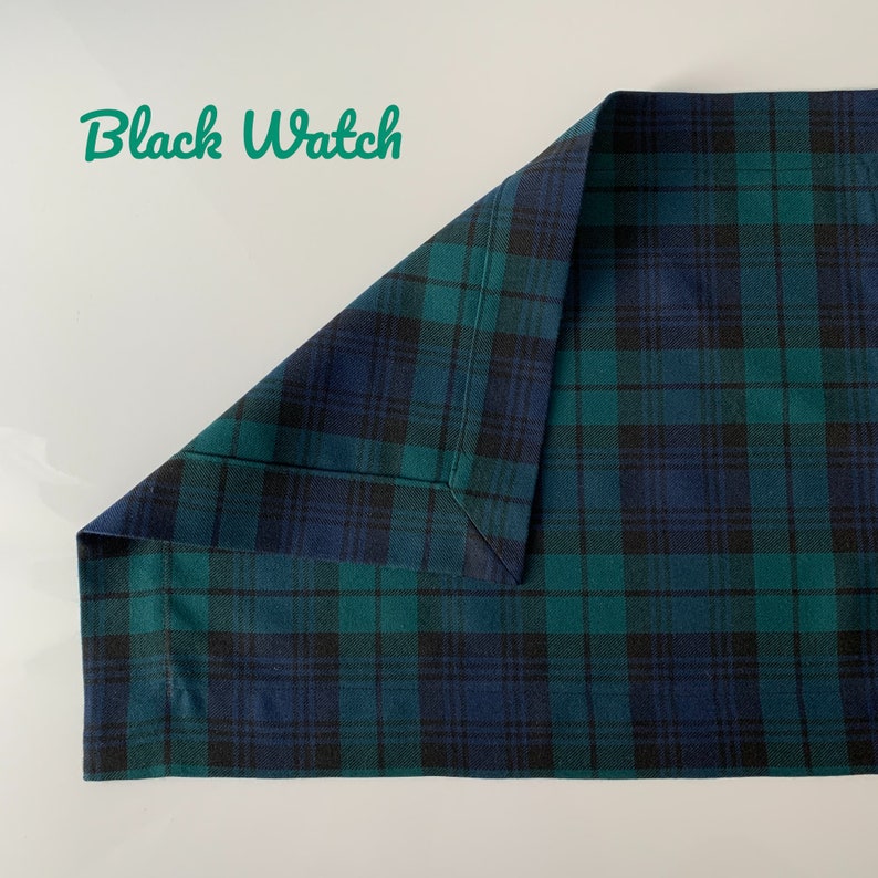 May include: A black and green plaid fabric with a folded corner. The fabric has a subtle sheen and a soft texture.