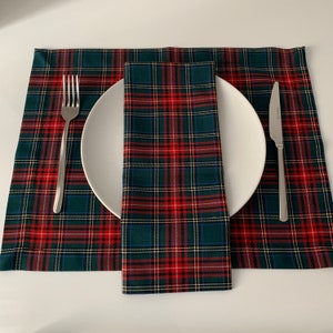 May include: A green, red, and white plaid placemat with a matching napkin and a white plate, fork, and knife.