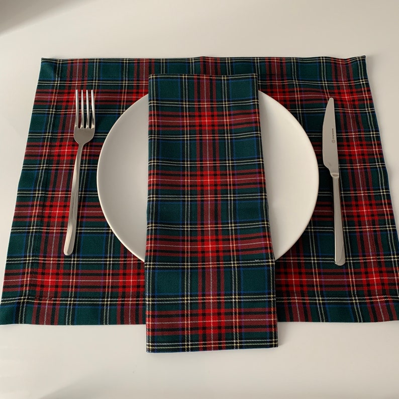 May include: A green, red, and white plaid placemat with a matching napkin and a white plate, fork, and knife.