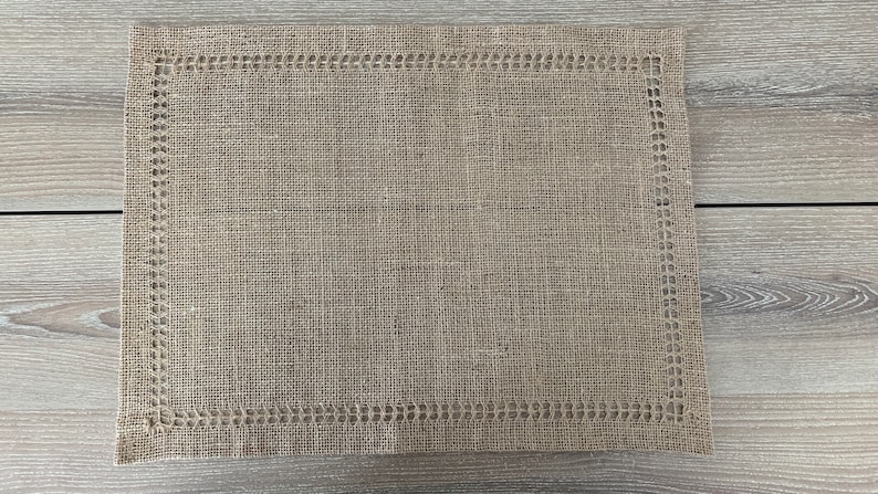 May include: A brown woven placemat with a decorative border. The placemat is made from a natural material and has a rustic look.