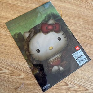 May include: A clear plastic document folder featuring a graphic illustration of the character Hello Kitty styled as the Mona Lisa, complete with long dark hair, a red bow, and a dark dress, set against a green landscape background with text.