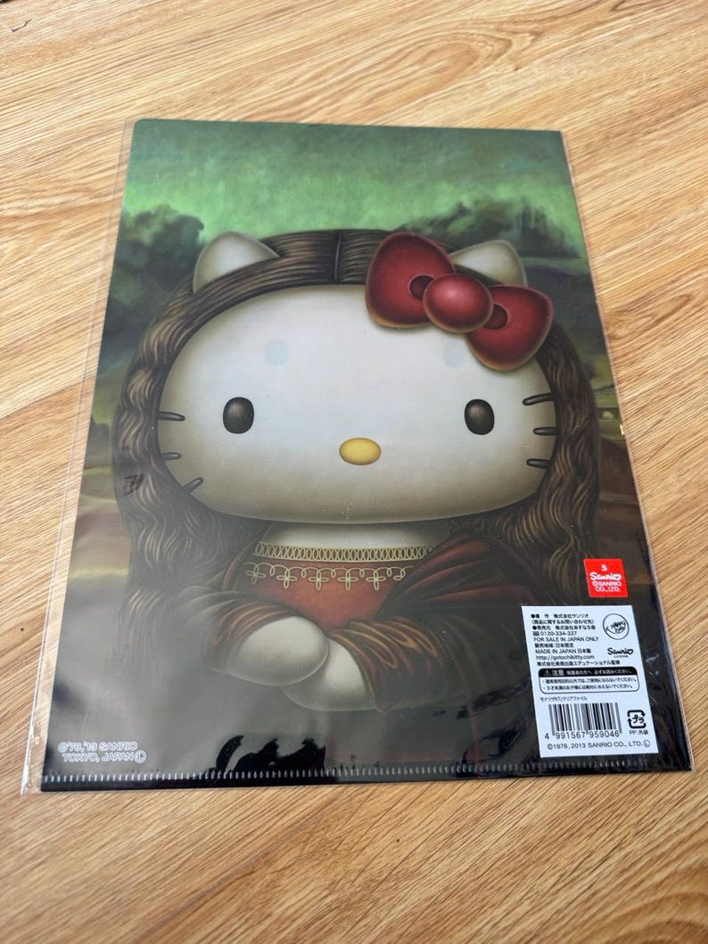 May include: A rectangular plastic clear file featuring a graphic of Hello Kitty styled as the Mona Lisa, with long brown hair, a red bow, and a dark dress. The background is a dark green landscape. Text includes Sanrio copyright details.