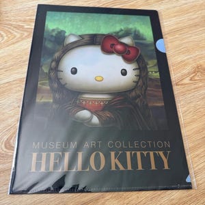 May include: A rectangular plastic document folder featuring a graphic of Hello Kitty styled as the Mona Lisa, complete with long dark hair, a red bow, and a dark dress. The text MUSEUM ART COLLECTION HELLO KITTY is printed in gold at the bottom.