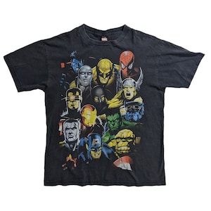 May include: Black t-shirt with a graphic print of various Marvel superheroes, including Spider-Man, Wolverine, Iron Man, and Captain America.