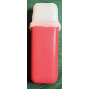May include: A red plastic container with a white top and a light pink band. The rectangular container is vertically oriented and appears to be a vintage kitchen item. The top is a rounded rectangle shape.