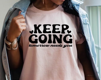 May include: A pink t-shirt with the text "KEEP GOING tomorrow needs you" in black.