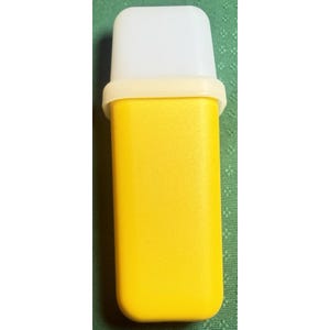 May include: A yellow plastic container with a white top and a light yellow band. The container is rectangular with rounded edges. The top is a solid white color. The container is likely used for storage or dispensing.