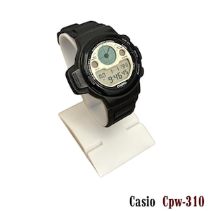 May include: Black Casio Cpw-310 digital watch with a white display showing the time. The watch has a black band and is displayed on a white stand. The watch face includes the Casio logo and various function labels.