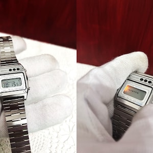 Puede incluir: Un reloj digital Seiko plateado con una esfera negra y una correa de metal plateado. El reloj tiene una pantalla digital que muestra la hora, la fecha y el d&iacute;a de la semana. El reloj tambi&eacute;n tiene una luz roja que ilumina la pantalla.