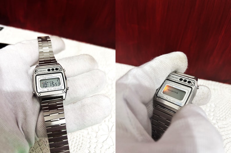 Puede incluir: Un reloj digital Seiko plateado con una esfera negra y una correa de metal plateado. El reloj tiene una pantalla digital que muestra la hora, la fecha y el d&iacute;a de la semana. El reloj tambi&eacute;n tiene una luz roja que ilumina la pantalla.