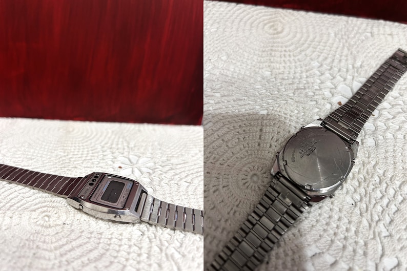 Puede incluir: Un reloj de pulsera digital plateado con una correa de acero inoxidable. La esfera del reloj tiene un fondo negro con n&uacute;meros blancos y una pantalla digital blanca. La parte posterior del reloj tiene las palabras "WATER RESIST" y "JAPAN MVT" impresas.
