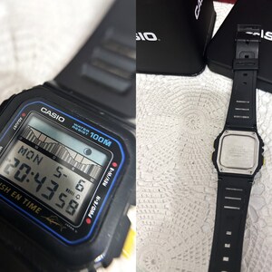 May include: Black Casio digital watch with a black band. The watch face displays the time, date, and day of the week. The watch is water resistant to 100 meters. The watch is in a black box.