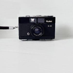 Rollei 35B Ultra Compact/ 35mm Film Camera / Retractable 40mm f3.5 Triotar lens + Rollei Wrist Strap/Orginal Case BLACK Color